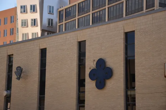 Two steel butterflies mounted to a brick building