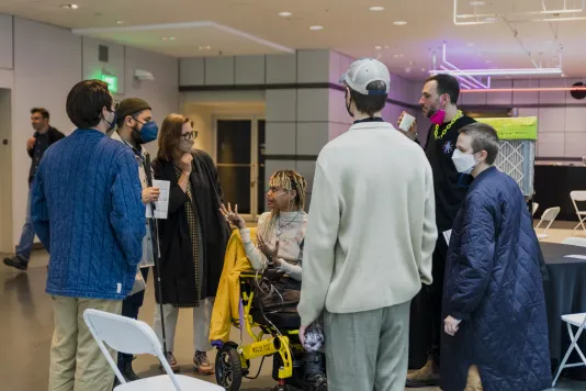 Event photograph from Altered Access. A group of participants are gathered in a circle discussing with one another.